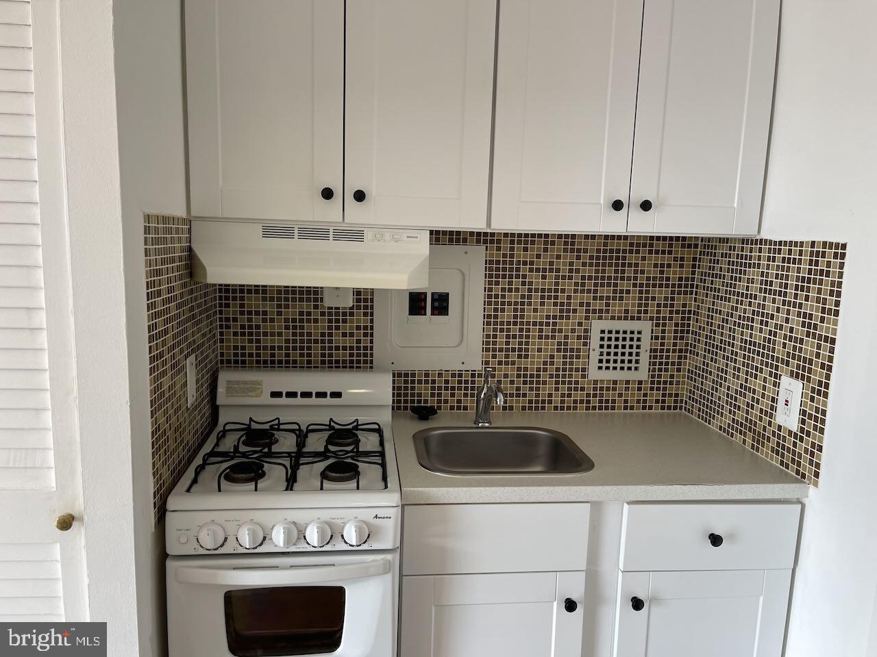 950 25th Street Northwest, Unit 1013N Washington, DC 20037 - Photo 6 of 27 a kitchen with a stove and white cabinets