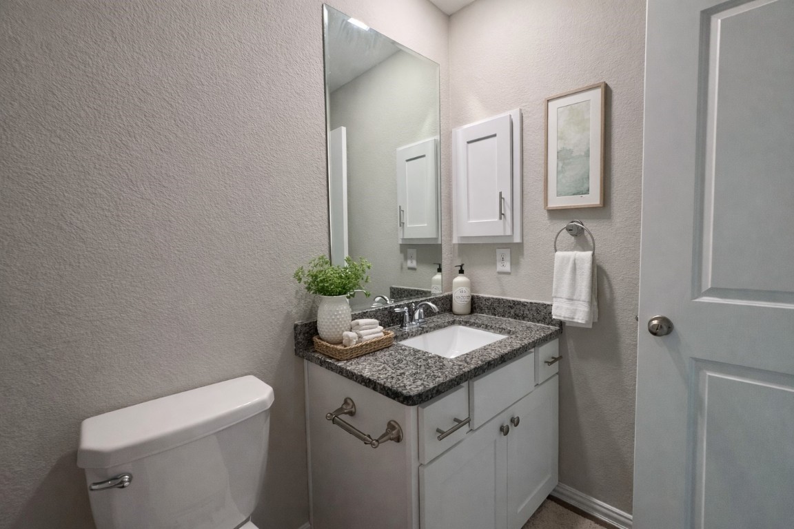 231 Moon Dance Court Conroe, TX 77304 - Photo 15 of 22 a bathroom with a granite countertop sink and a toilet