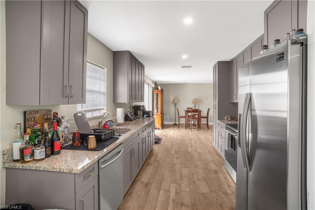 4500 30th Place Southwest Naples, FL 34116 - Photo 6 of 15 a kitchen with stainless steel appliances granite countertop a refrigerator a sink and a stove