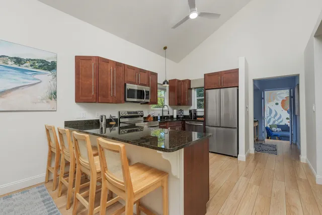 a kitchen with granite countertop a refrigerator and a stove top oven