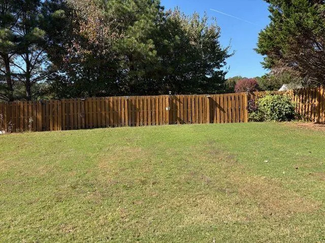 a view of backyard with wooden fence