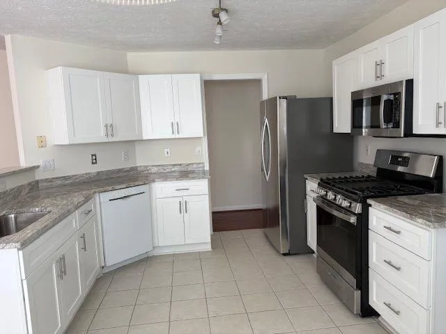 a kitchen with granite countertop cabinets and steel stainless steel appliances