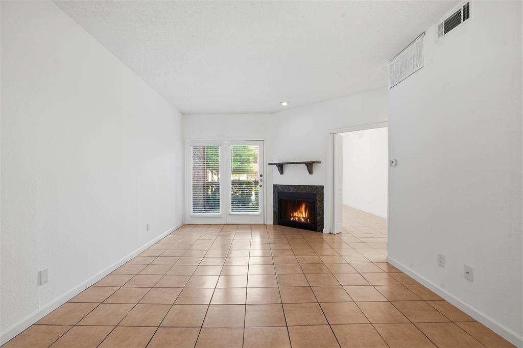 5550 Spring Valley Road, Unit F14 Dallas, TX 75254 - Photo 1 of 15 a view of an empty room with a fireplace and a window