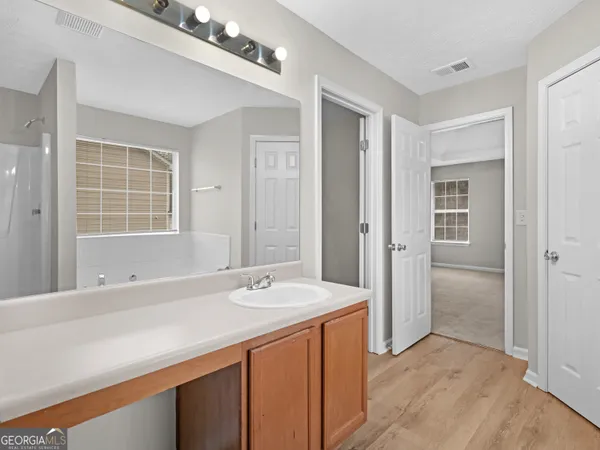 a spacious bathroom with a shower sink and mirror