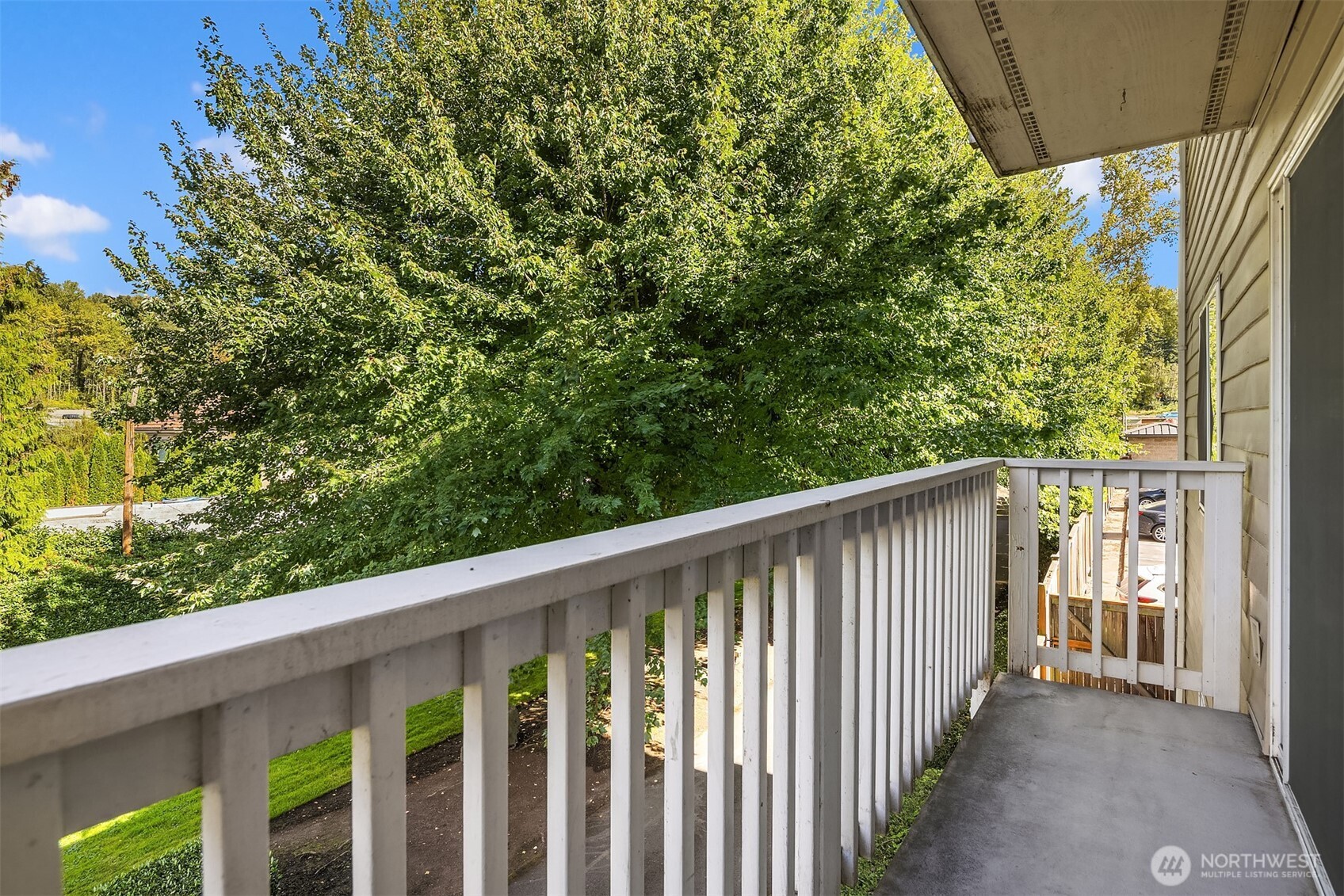 5021 Ripley Lane North, Unit 211 Renton, WA 98056 - Photo 18 of 25 a side view of a wooden balcony with green trees
