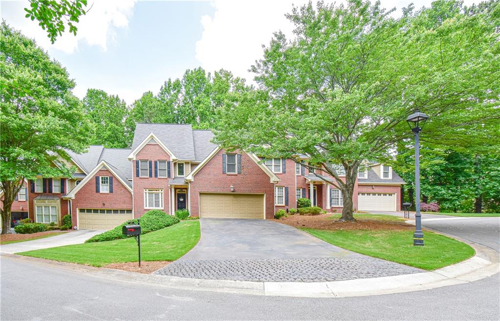 7155 Roswell Road, Unit 49 Sandy Springs, GA 30328 - Photo 1 of 1 a front view of a house with a garden and trees