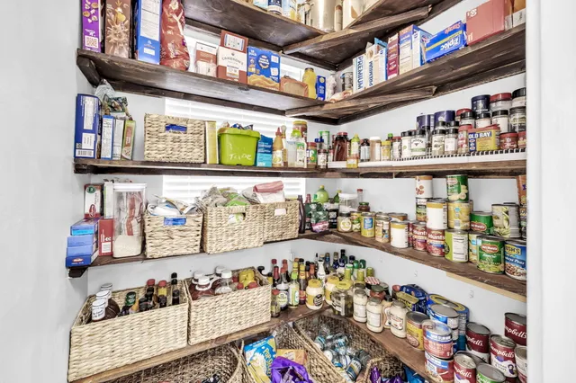 a kitchen with stainless steel appliances kitchen island granite countertop a stove a refrigerator and white cabinets with wooden floor