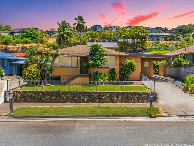 a view of a house with a big yard and a large trees