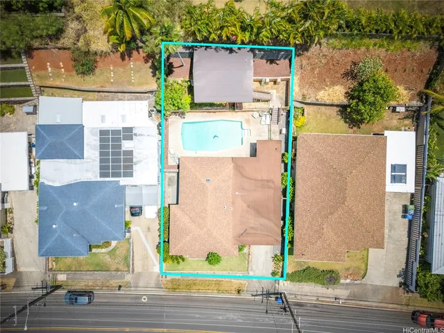 an aerial view of a house with a yard and seating space