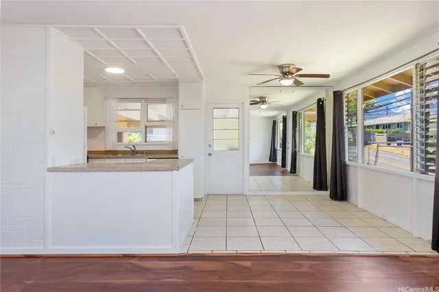 a view of a hallway with wooden floor and a living room