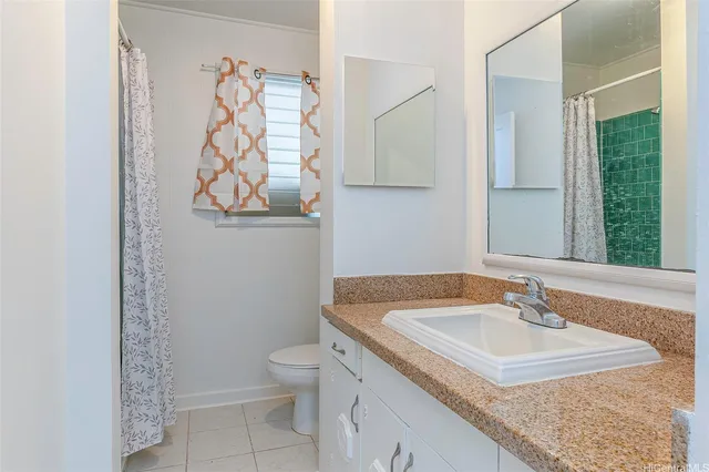 a bathroom with a granite countertop sink a toilet and a mirror