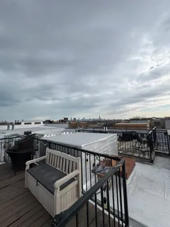 a view of a roof deck with couches with wooden floor