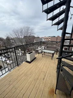a view of roof deck with wooden floor and fence