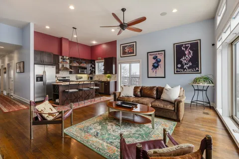 a living room with stainless steel appliances kitchen island granite countertop furniture and a view of kitchen