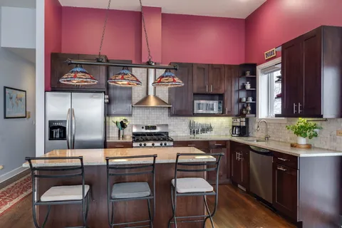 a kitchen with stainless steel appliances granite countertop a stove a sink dishwasher and cabinets with wooden floor