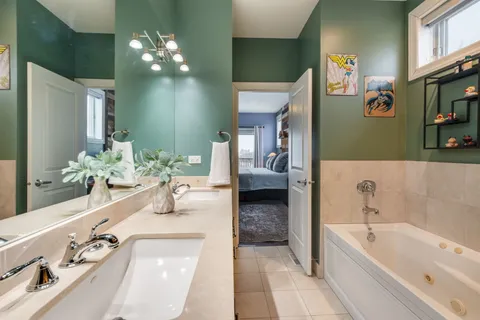a bathroom with a tub sink and mirror