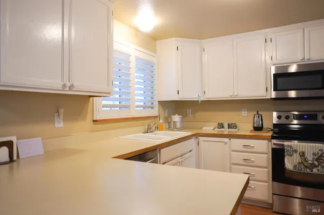 a kitchen with stainless steel appliances granite countertop a sink a stove and cabinets