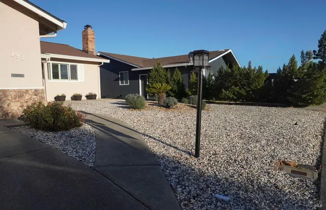 a view of a house with backyard and sitting area