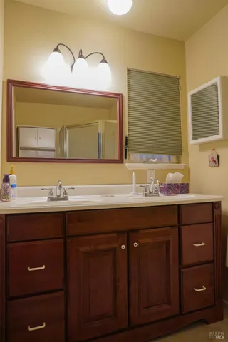 a bathroom with a granite countertop sink and a mirror