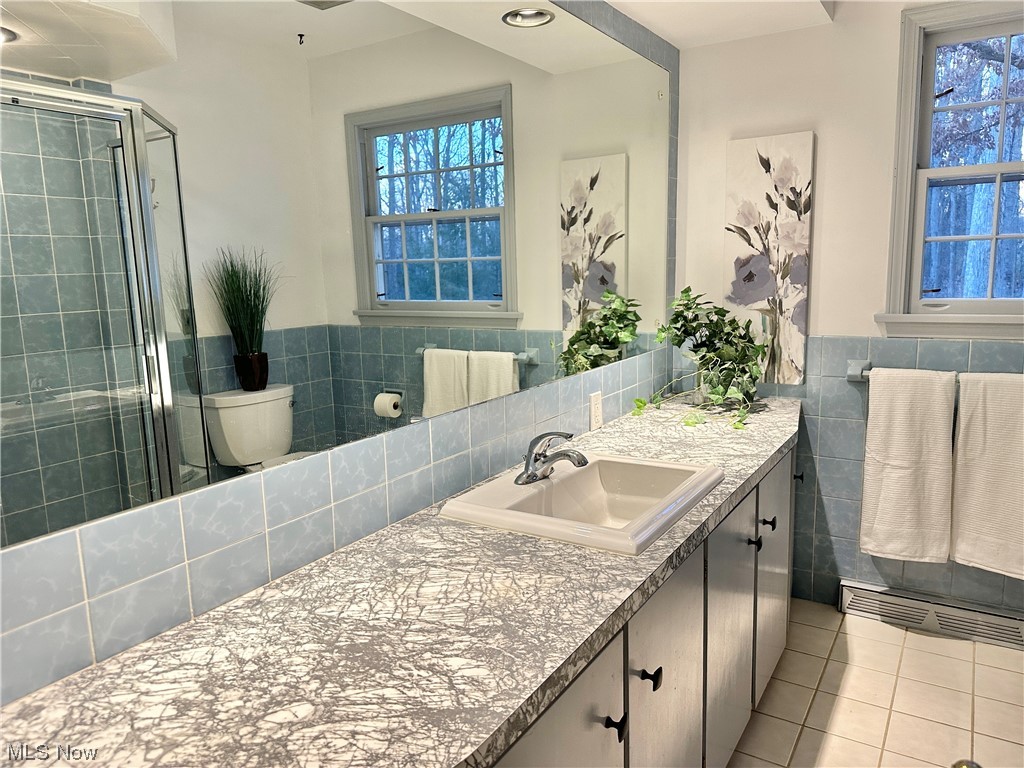 6130 Renninger Road New Franklin, OH 44319 - Photo 15 of 30 Hall Full Bathroom with a wealth of natural light, tile floors, oversized vanity,shower & toilet