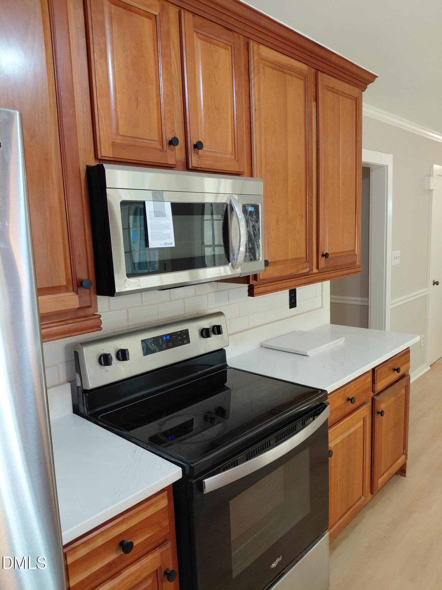 804 Olive Street Apex, NC 27502 - Photo 17 of 60 a kitchen with wooden cabinets and a stove top oven