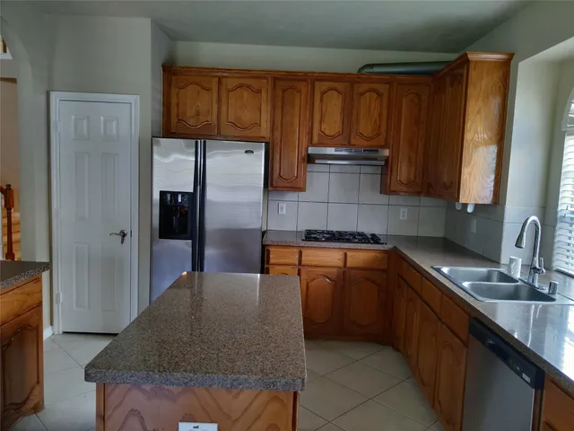 a kitchen with stainless steel appliances granite countertop a sink stove and refrigerator