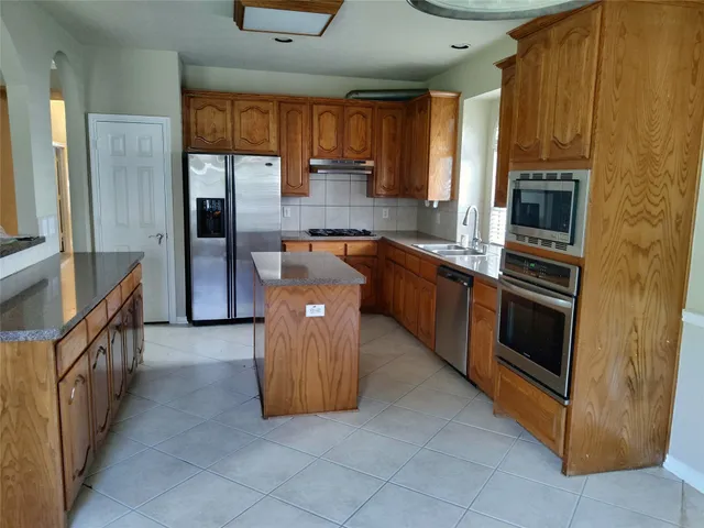 a kitchen with stainless steel appliances granite countertop a refrigerator and a stove