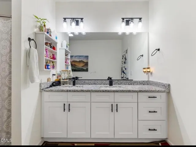 a bathroom with a granite countertop sink and a mirror