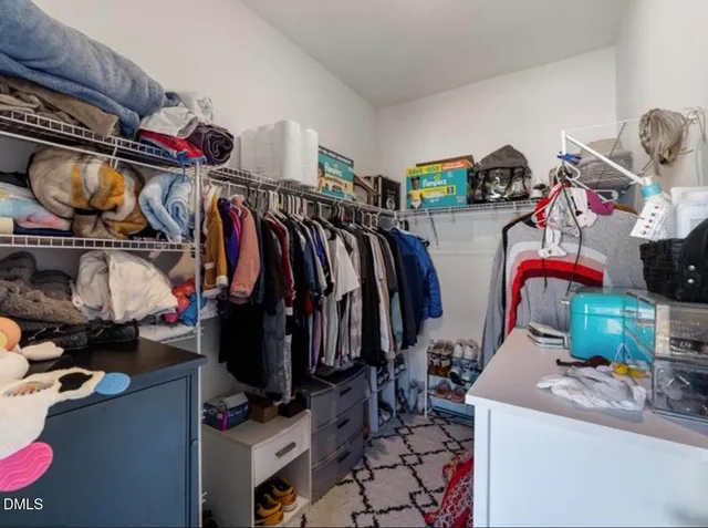 a view of walk in closet with clothes and shoes