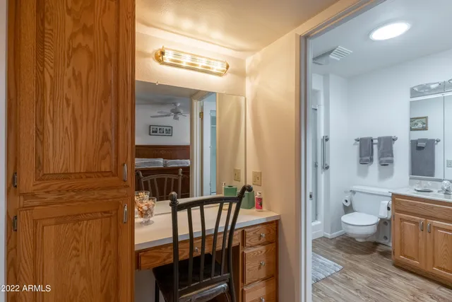 a view of a hallway with bathroom and wooden floor
