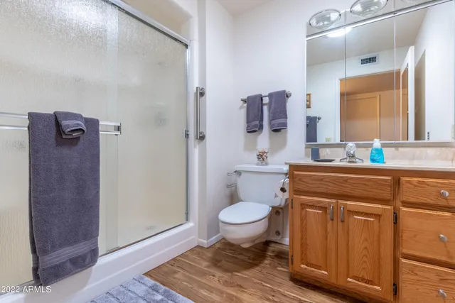 a bathroom with a granite countertop sink toilet and mirror