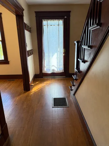 a view of an entryway with wooden floor and door