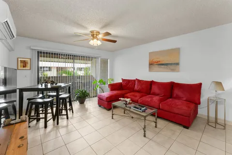a living room with furniture a flat screen tv and a large window