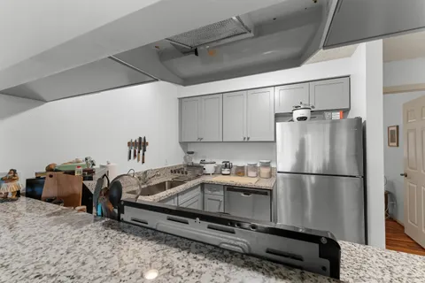 a kitchen with a refrigerator and a stove top oven