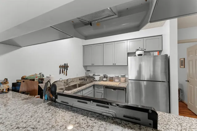 a kitchen with a refrigerator and a stove top oven