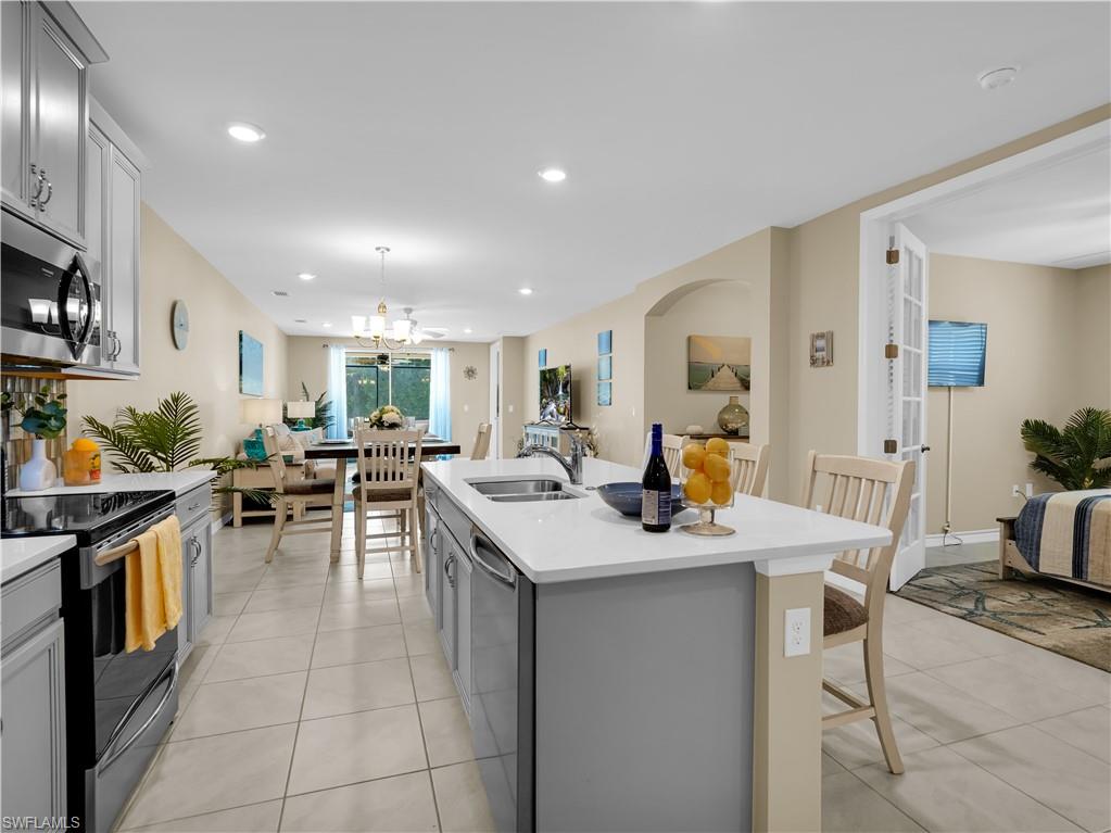 14695 Edgewater Circle Naples, FL 34114 - Photo 12 of 39 a view of a kitchen with kitchen island a sink table and chairs