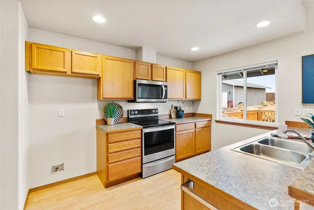a kitchen with a sink a counter top space stainless steel appliances and a window