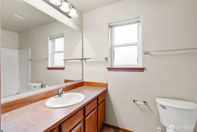 a bathroom with a granite countertop sink toilet a large mirror and shower