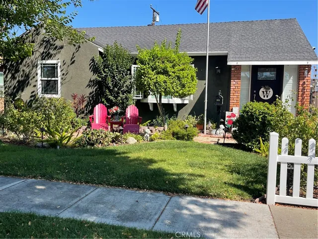 a front view of house and yard with seating and green space