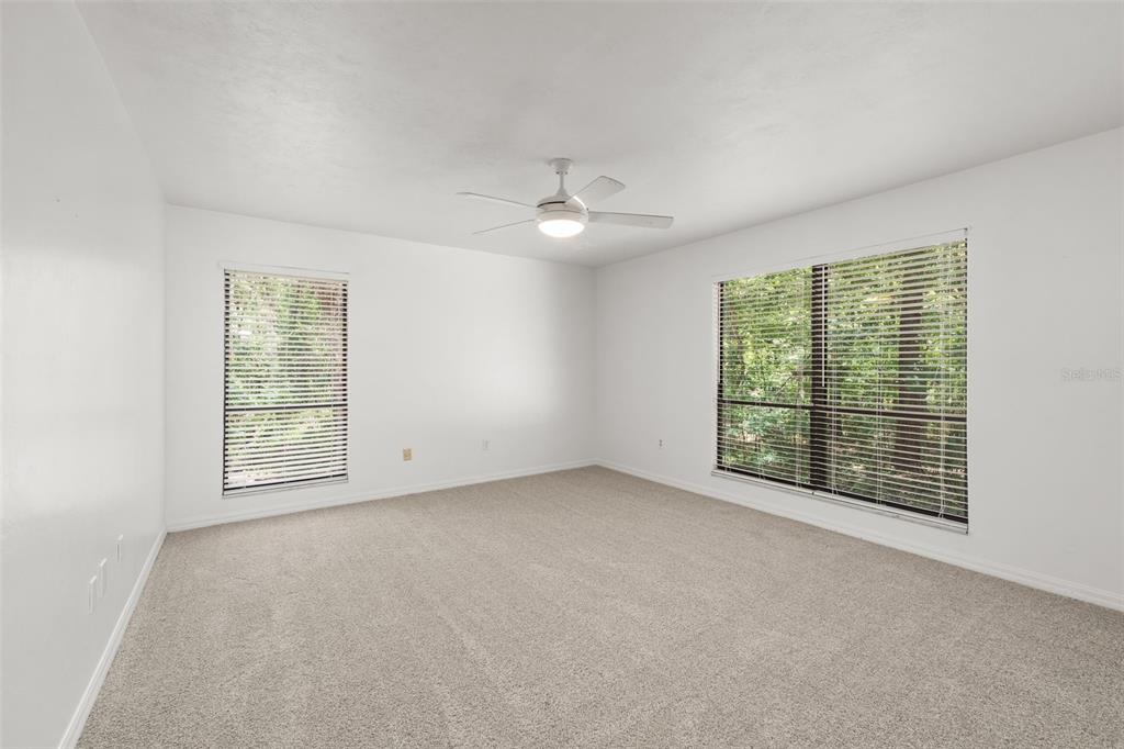4703 Northwest 124th Street Gainesville, FL 32606 - Photo 35 of 55 an empty room with windows and ceiling fan