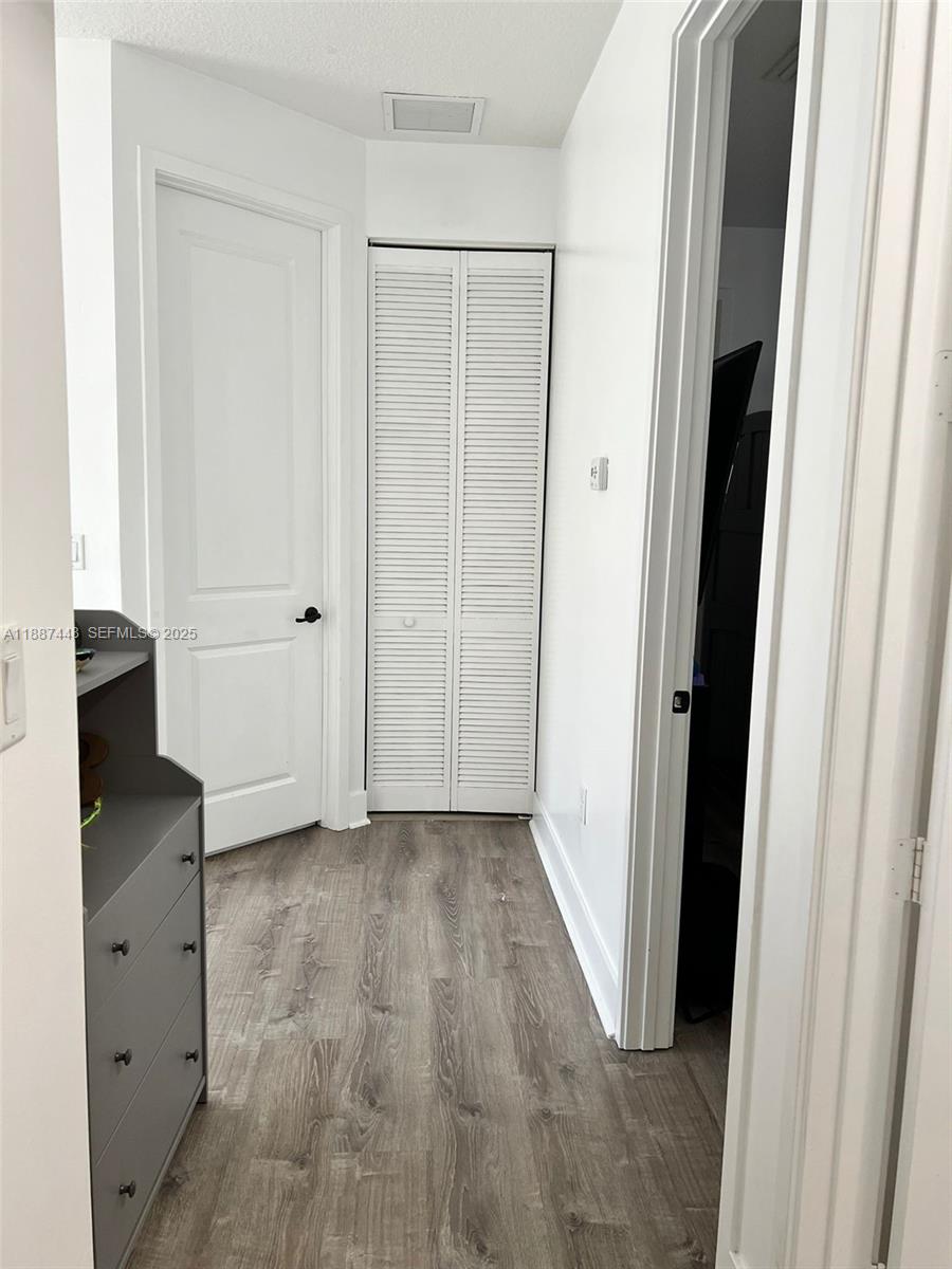 3214 West 97th Street Hialeah, FL 33018 - Photo 18 of 22 an empty room with cabinet and wooden floor