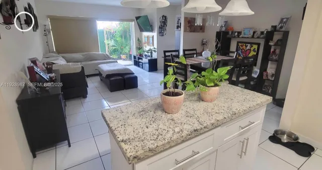 a kitchen with stainless steel appliances kitchen island granite countertop a sink a counter space and cabinets