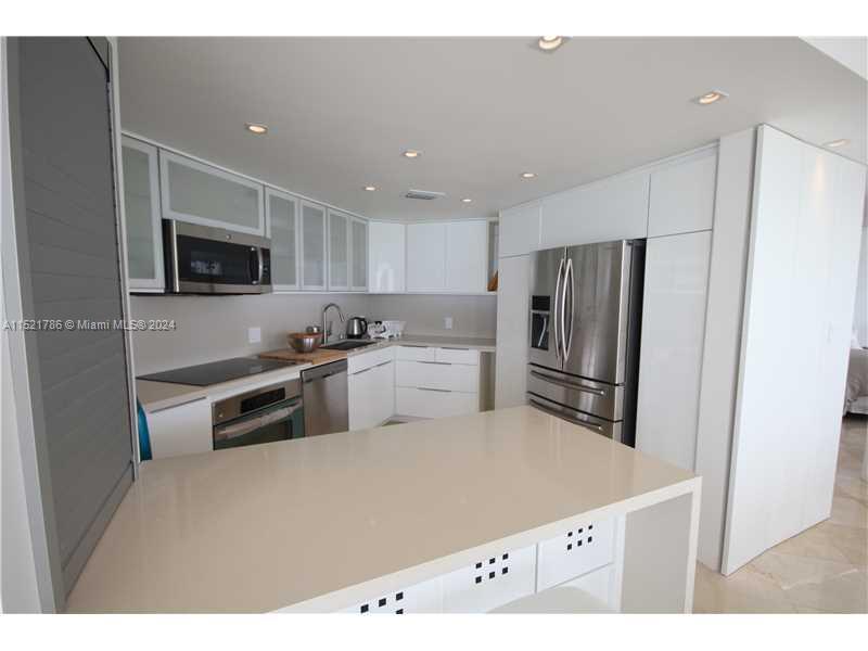 5151 Collins Avenue, Unit 532 Miami Beach, FL 33140 - Photo 13 of 62 a kitchen with stainless steel appliances a refrigerator sink and microwave