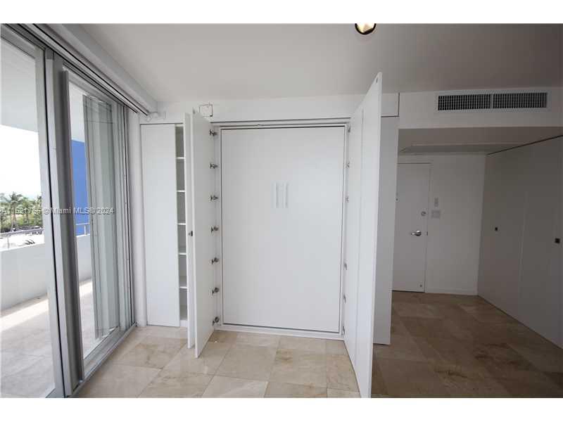 5151 Collins Avenue, Unit 532 Miami Beach, FL 33140 - Photo 14 of 62 a view of an empty room with wooden floor and a window
