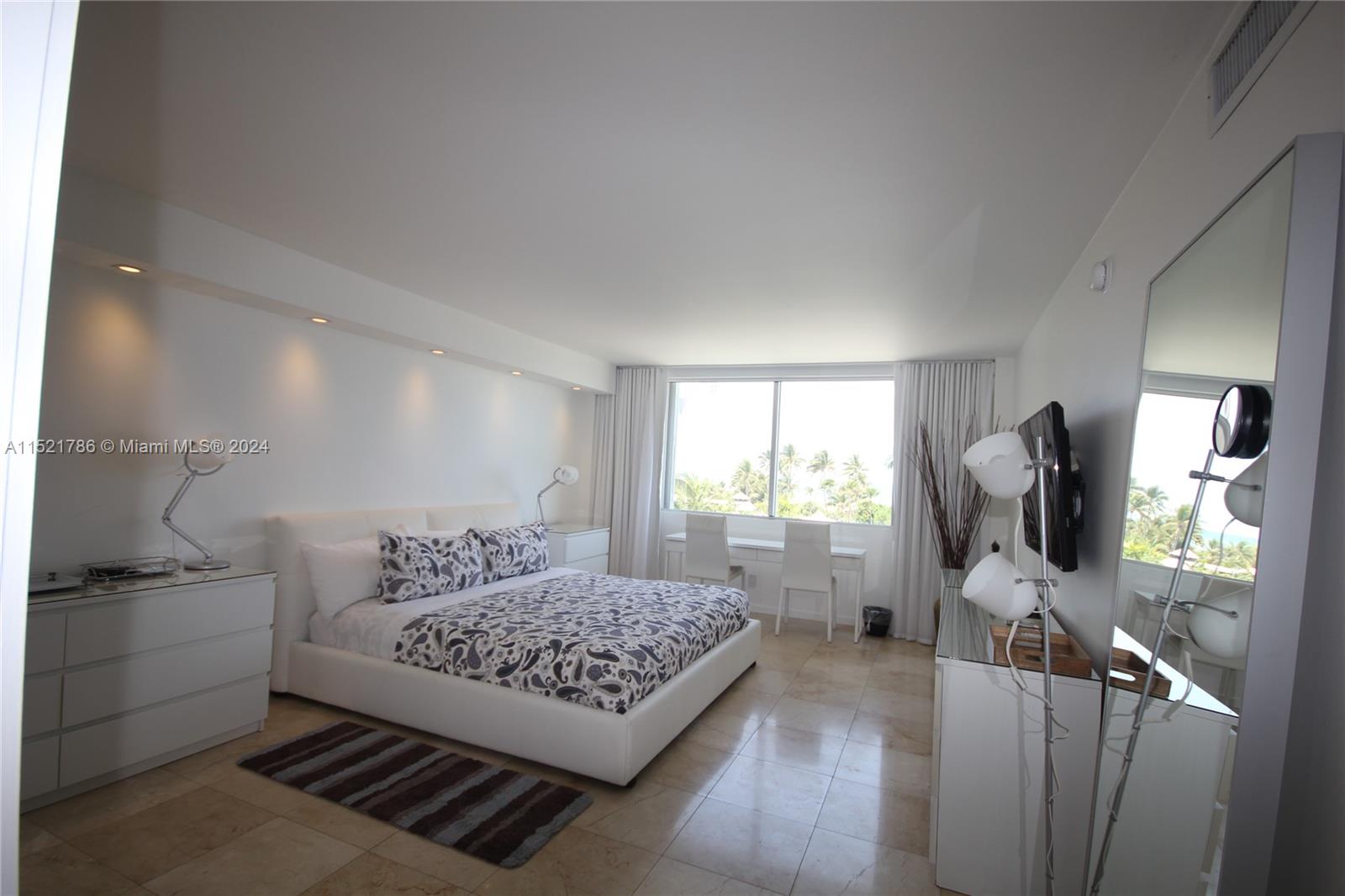 5151 Collins Avenue, Unit 532 Miami Beach, FL 33140 - Photo 15 of 62 a bedroom with a bed flat screen tv and window
