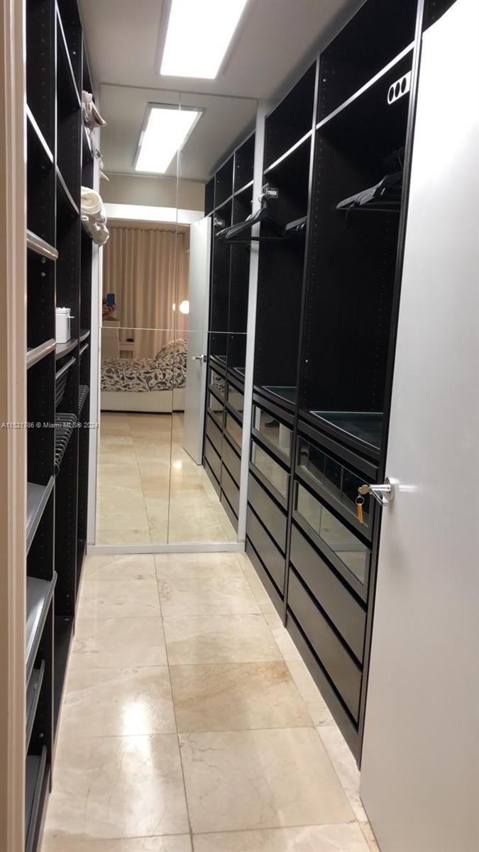 5151 Collins Avenue, Unit 532 Miami Beach, FL 33140 - Photo 20 of 62 a view of walk in closet with clothes and shoes