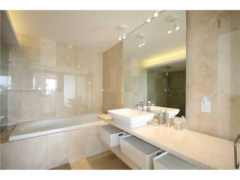 5151 Collins Avenue, Unit 532 Miami Beach, FL 33140 - Photo 21 of 62 a bathroom with a sink mirror and a shower