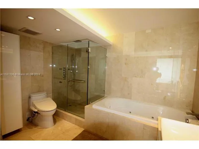 a bathroom with a bathtub shower sink vanity and toilet