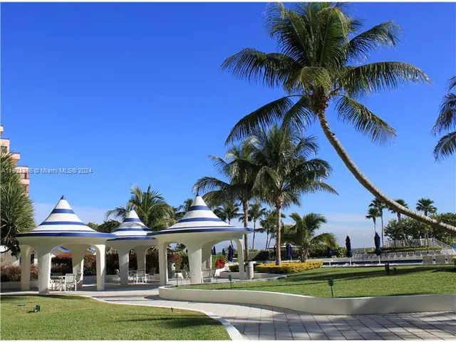 a view of swimming pool with outdoor seating and trees in the background