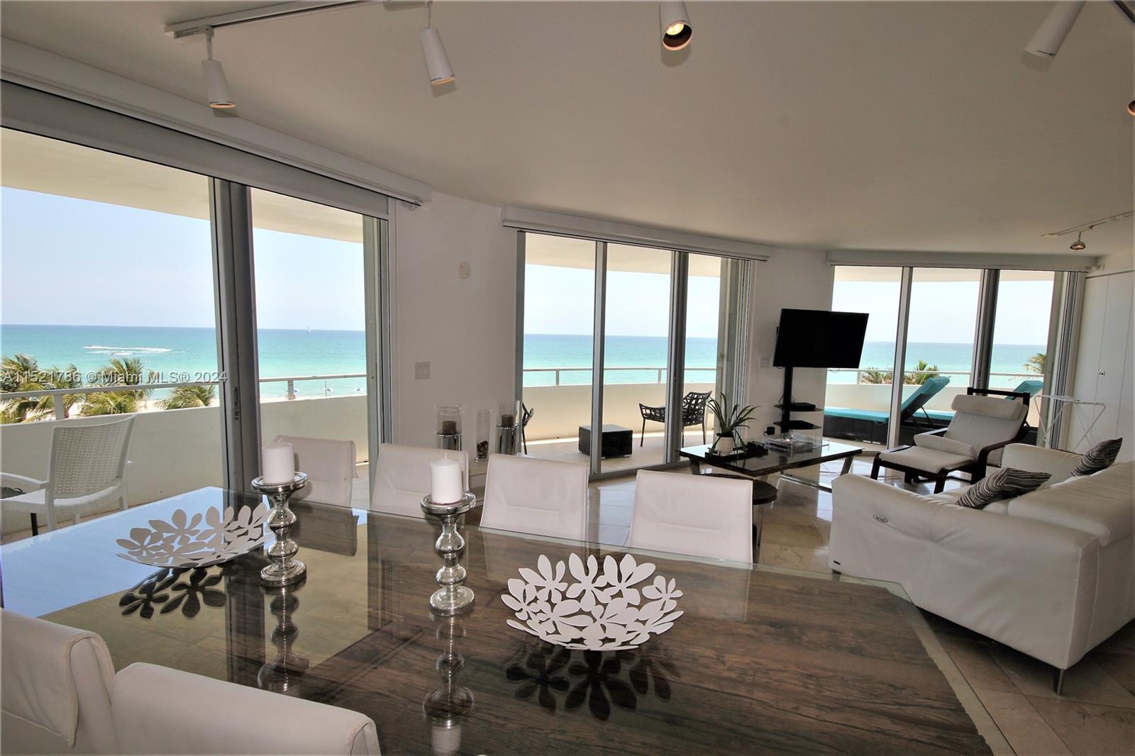5151 Collins Avenue, Unit 532 Miami Beach, FL 33140 - Photo 4 of 62 a living room with furniture and floor to ceiling windows